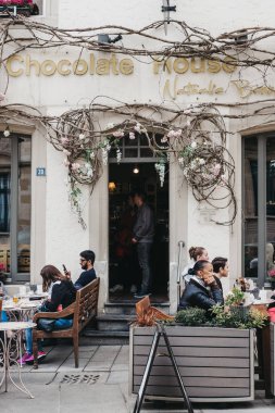 Nathalie tarafından Chocolate House açık masalarda oturan insanlar 