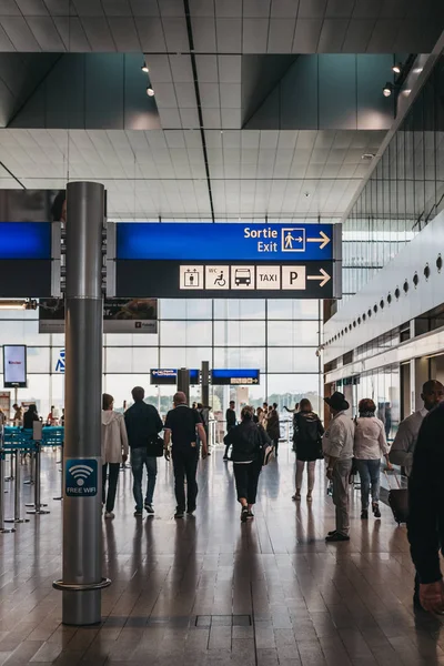 Personnes passant devant les panneaux directionnels à Aéroport de Luxembourg-Ville — Photo