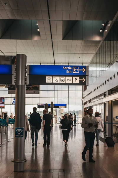 People walking past directional signs in Luxembourg City airport — Stock Photo, Image