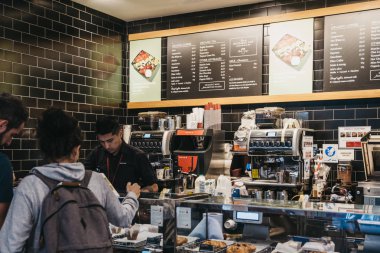 Barista içeride müşterilere servis yapıyor. Bir yemlik sandviç dükkanı, Lo.