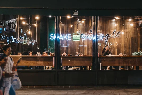 Vista pela janela das pessoas dentro do restaurante Shake Shack — Fotografia de Stock