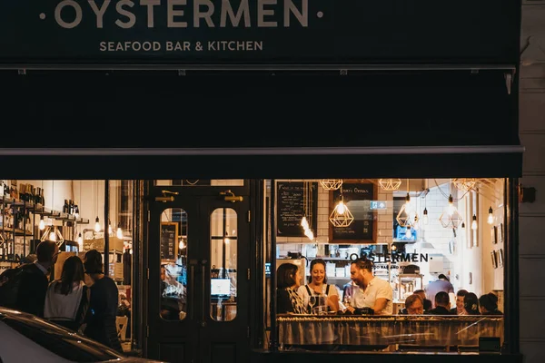 Vista através da janela de pessoas dentro do restaurante Oysterman em — Fotografia de Stock