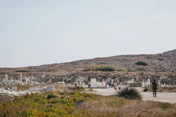 Les gens marchent parmi les ruines sur l'île de Delos, Grèce . — Photo