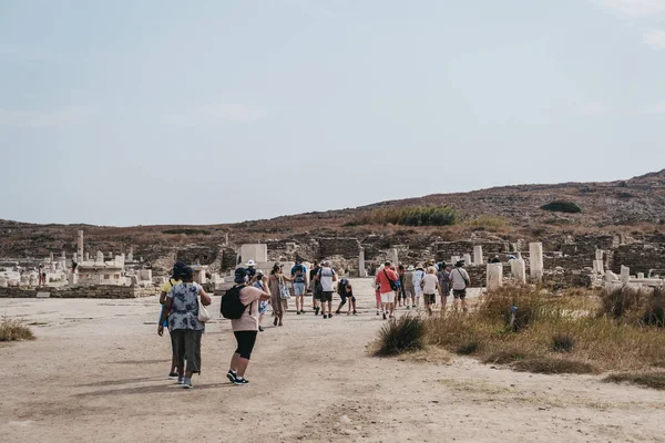 Les gens marchent parmi les ruines sur l'île de Delos, Grèce . — Photo