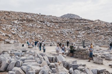Tarihi tiyatronun kalıntıları arasında yürüyen turistler 