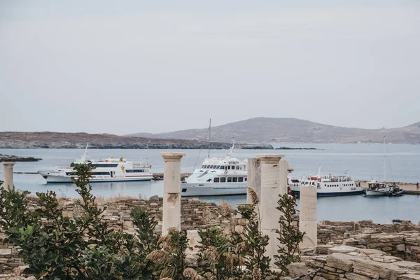 Ruines sur l'île de Delos, Grèce, bateaux d'excursion amarrés sur le b — Photo