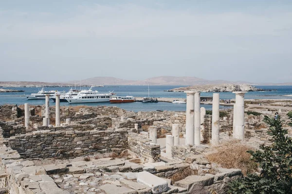 Ruines sur l'île de Delos, Grèce, bateaux d'excursion amarrés sur le b — Photo