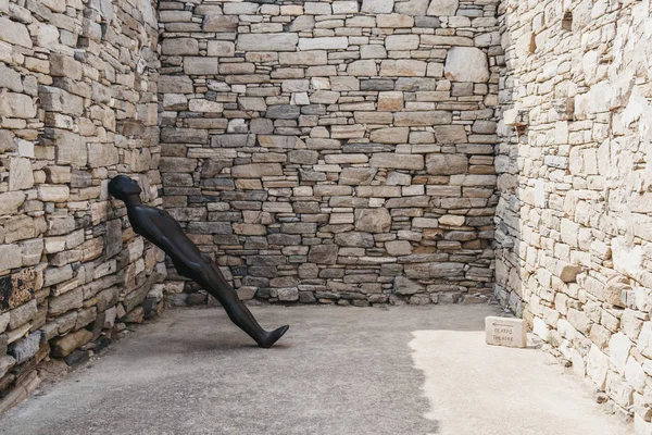 Metal man bodyform leaning statue by Antony Gormley on the Greek — Stock Photo, Image