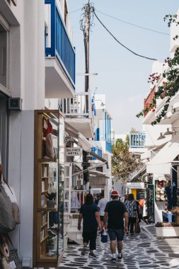 İnsanlar Hora 'da dar bir sokakta dükkanların önünden geçiyorlar.
