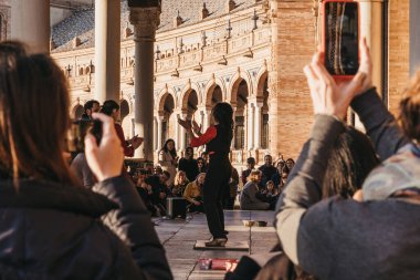 Seville, İspanya - 17 Ocak 2020: Flamenko dansçısı Flamenko 'nun doğduğu yer olan Seville, Endülüs' teki Plaza de Espana 'da kalabalığın önünde konser verdi. Seçici odaklanma, insanlar cep telefonlarıyla fotoğraf çekiyor..