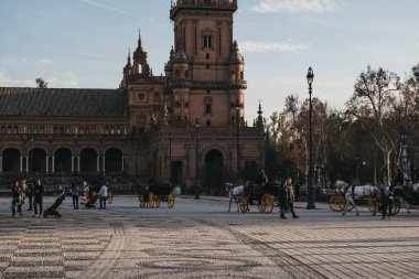 Seville, İspanya - 17 Ocak 2020: Plaza de Espana 'da şehir turu at arabaları, Seville, İspanya' da bir plaza, 1928 yılında Ibero-Amerikan Sergisi için inşa edildi..