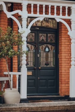 Londra, İngiltere - 26 Mayıs 2020: Londra 'daki geleneksel Edwardian evinin siyah boyalı ön kapısı, seçici odak noktası. Edwardian evleri basit bir tasarım ve el yapımı için bir takdir sunar..