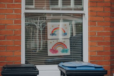 Londra, İngiltere - 30 Mayıs 2020: Coronavirus yüzünden insanlar birbirlerini desteklerken Londra 'daki bir evin penceresinde gökkuşağı tabelaları halka gösterildi.