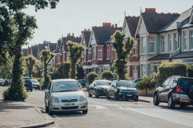 Londra, İngiltere - 26 Mayıs 2020: Kuzey Londra 'daki Londra Enfield İlçesi' nde bir banliyö bölgesi olan Palmers Green 'de bir caddenin her iki tarafındaki evlerin önüne park edilmiş arabalar.