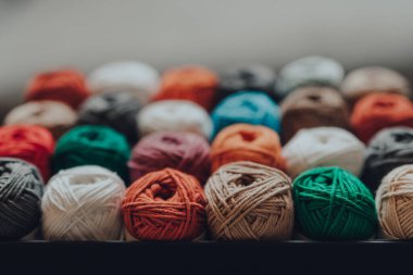 24 farklı renkte Amigurumi pamuğuyla dolu bir kutuyu kapat. En yakın satıra odaklan..