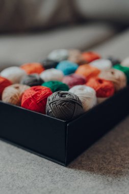 Amigurumi pamuk iplikleriyle dolu bir kutuyu farklı renklerde kapat. En yakın skein 'e odaklan..