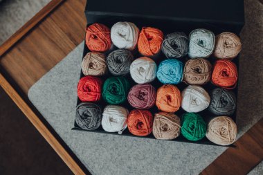 24 farklı renkte Amigurumi pamuğundan oluşan bir kutunun yukarıdan çekimi, seçici odak noktası..