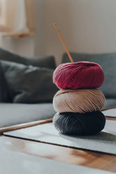 テーブルの上に木製のかぎ針編みのフックを持つDk糸の3つの異なる色のボールのスタック アパート内 浅い焦点 — ストック写真