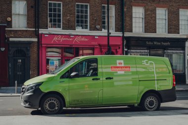 Londra, İngiltere - 13 Haziran 2020: Londra 'da bir sokakta yeşil elektrikli posta minibüsü. Son yıllarda Kraliyet Postası aktif olarak karbon ayak izini azaltmak için elektrikli araç sayısını artırır.
