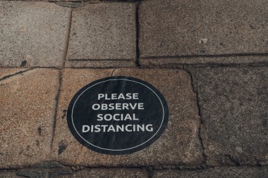 Lütfen Londra, İngiltere 'de bir caddenin kaldırımındaki sosyal mesafe tabelasına dikkat edin..