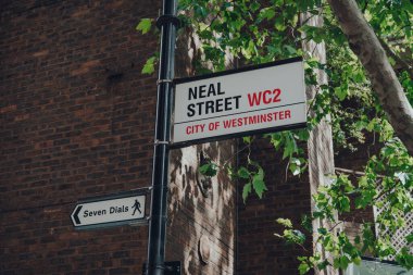 Londra, İngiltere - 13 Haziran 2020: Covent Garden 'daki Neal Caddesi' ndeki sokak ismi tabelası, güneşli bir yaz gününde Londra 'nın barları, restoranları ve kafeleri ile ünlüdür..