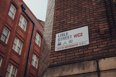 Londra, İngiltere - 13 Haziran 2019: Çin Mahallesi Lisle Sokağı 'nda İngilizce ve Mandarin sokak adı. Çin Mahallesi büyük bir Doğu Asya toplumuna ev sahipliği yapar ve yemek ve etkinlikleriyle ünlüdür..