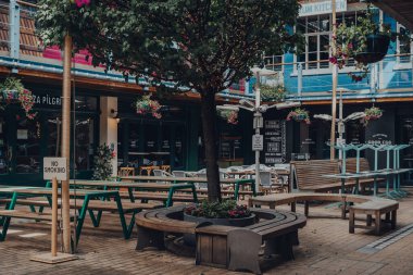 Londra, İngiltere - 13 Haziran 2020: Londra West End 'in göbeğinde yer alan üç katlı açık büfe yemek ve yemek avlusu Kingly Court' taki boş masalar. Seçici odak.