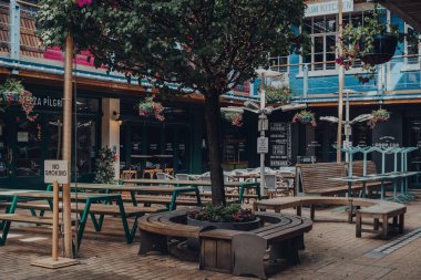 Londra, İngiltere - 13 Haziran 2020: Londra West End 'in göbeğinde yer alan üç katlı açık büfe yemek ve yemek avlusu Kingly Court' taki boş masalar. Seçici odak.