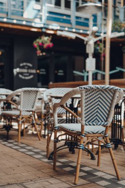 Açık hava sandalyeleri ve bir restoranın masaları, seçici sığ odak.