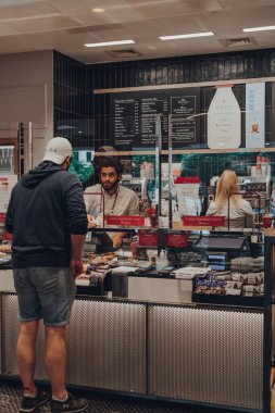 Londra, İngiltere - 07 Eylül 2019: Pret a Manger 'ın içindeki tezgahtan yiyecek sipariş eden tek müşteri, koruyucu plastik ekran ile baristadan ayrıldı. Değişiklikler Coronavirus nedeniyle başlatıldı..