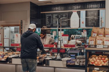 Londra, İngiltere - 07 Eylül 2019: Pret a Manger 'ın içindeki tezgahtan yiyecek sipariş eden tek müşteri, koruyucu plastik ekran ile baristadan ayrıldı. Değişiklikler Coronavirus nedeniyle başlatıldı..