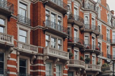 Kensington, Chelsea, Londra ve İngiltere 'de balkonları olan geleneksel kırmızı tuğlalı apartman bloğu..