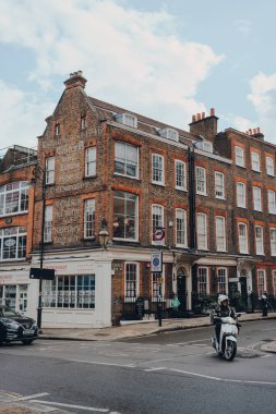 Londra, İngiltere - 2 Temmuz 2020: Hampstead 'de Heath Street ve Church Row' un köşesindeki kurye bisikletçi, Londra 'nın varlıklı yerleşim bölgesi, sanatçılar ve medya figürleri tarafından tercih ediliyor.