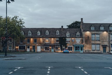 Wold-Stow-on-the-Wold, İngiltere - 6 Temmuz 2020: Cotswolds 'da bir pazar kasabası olan Stow-on-the-Wold' da, akşam saatlerinde neredeyse boş bir otoparkın üzerinde görüldü..
