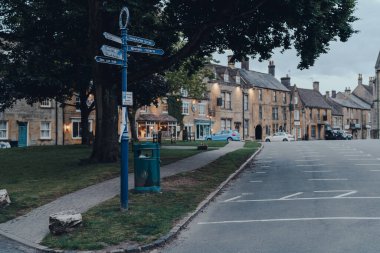 Stow-on-the-Wold, İngiltere - 6 Temmuz 2020: Cotswolds 'da bir pazar kasabası olan Stow-on-the-Wold' da bir caddede yön tabelaları olan işaret levhası. Seçici odak.