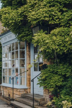 Stow-on-the-Wold, İngiltere - 10 Temmuz 2020: Cotswolds, İngiltere 'de bir pazar kasabası olan Stow-on-the-Wold' daki Jaffe & Neale kitapçısına ve kafeye giriş, Roman Fosse Yolu üzerine inşa edilmektedir..