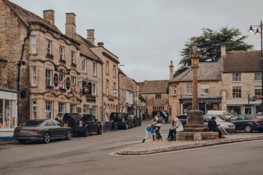 Stow-on-the-Wold, İngiltere - 10 Temmuz 2020: Cotswolds, İngiltere 'de bir pazar kasabası olan Stow-on-the-Wold' da insanlar ve park edilmiş arabalar Roman Fosse Yolu üzerine inşa ediliyor.