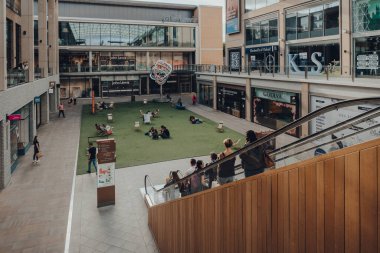 Oxford, İngiltere - 4 Ağustos 2020: Yürüyen merdivendeki insanlar Oxford, İngiltere 'deki büyük bir alışveriş merkezi olan Westgate Center' ın avlusundan aşağı iniyorlar..