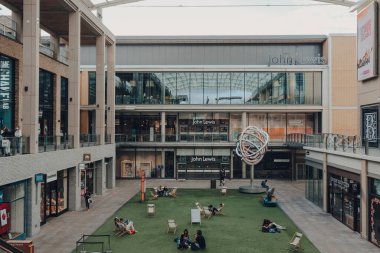 Oxford, İngiltere - 4 Ağustos 2020: Oxford şehir merkezinde büyük bir alışveriş merkezi olan Westgate Centre 'ın avlusunda dinlenen insanlar.