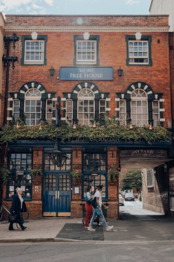 Oxford, İngiltere - 4 Ağustos 2020: Oxford, İngiltere 'de tipik bir Victorian barı olan St Aldates Tavern' ın önünden geçen insanlar, hareket bulanıklığı.