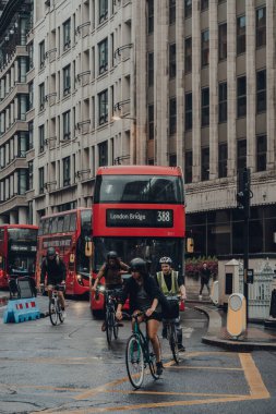 Londra, İngiltere - 24 Ağustos 2020: Bisikletçiler ve kırmızı çift katlı otobüsler Londra şehrinin tarihi bir finans bölgesi olan Motion Blur 'da hareket halindedir..