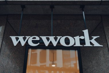 Londra, İngiltere - 24 Ağustos 2020: Londra 'daki WeWork şehrinin dışındaki isim tabelası. 2010 yılında kurulan WeWork, teknoloji girişimleri ve diğer şirketler için popüler ortak çalışma alanları..