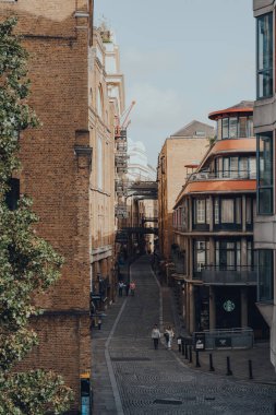 Londra, İngiltere - 25 Ağustos 2020: Bermondsey, Londra 'daki Tower Bridge' in yanındaki tarihi nehir kenarı caddesi Shad Thames 'de yürüyen insanların yüksek açılı görüntüsü.
