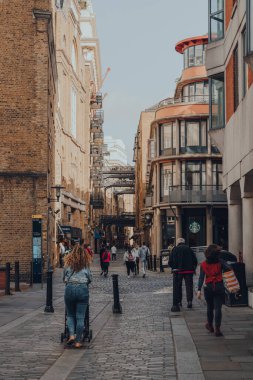 Londra, İngiltere - 25 Ağustos 2020: Bermondsey, Londra 'daki Tower Bridge' in yanındaki tarihi nehir kenarı caddesi Shad Thames 'de yürüyen insanlar. Hareket bulanıklığı.