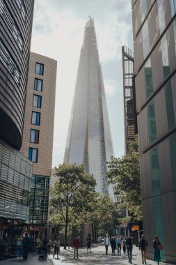 Londra, İngiltere - 25 Ağustos 2020: More London 'daki binalar arasındaki Çömlek Manzarası, önde yürüyen insanlar. Çömlek Londra 'nın en popüler simgelerinden biri..