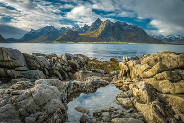 Lofote 'de dağları ve fiyortları olan kayalık bir sahilin manzarası.