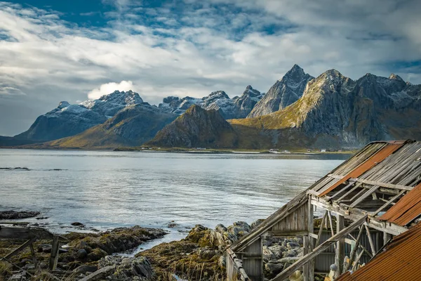 Dağları, fiyortları ve eski bir B ile kayalık bir sahilin manzarası.