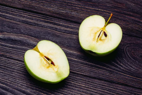 Ripe apple cut in half on a wooden surface — Stock Photo, Image