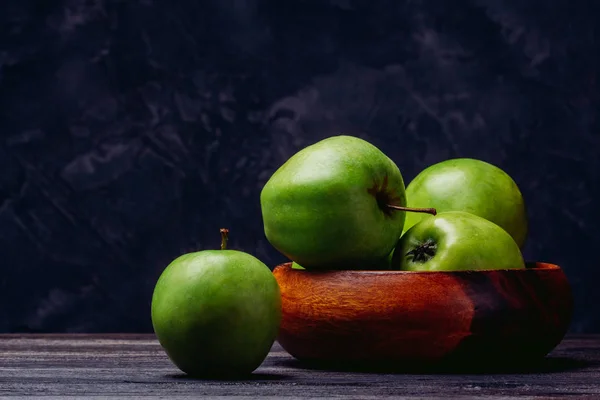 Beautiful juicy apples in a bowl on a table — Stock Photo, Image