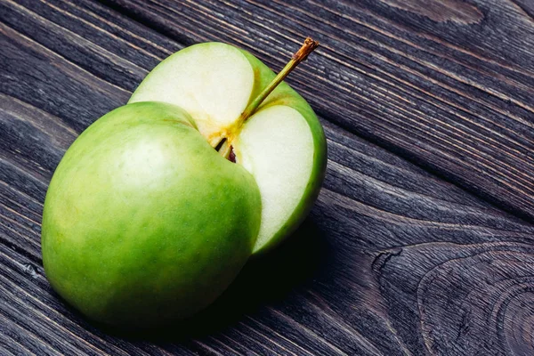 Ripe green apple cut into two pieces — Stock Photo, Image